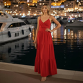 Woman wearing red women's tiered dress with adjustable spaghetti straps standing by marina at night